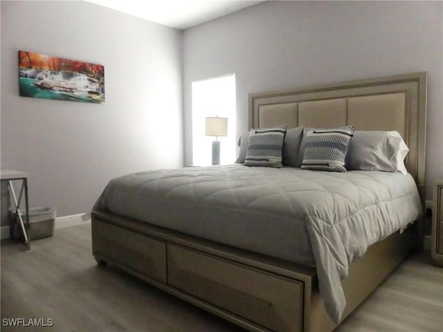 bedroom featuring light wood-style floors and baseboards