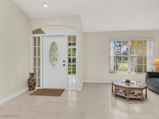 foyer entrance featuring light tile patterned flooring and baseboards