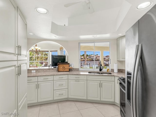 kitchen featuring stainless steel appliances, a healthy amount of sunlight, white cabinets, and a sink