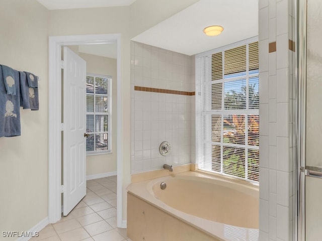 bathroom with a garden tub, an enclosed shower, tile patterned flooring, and baseboards