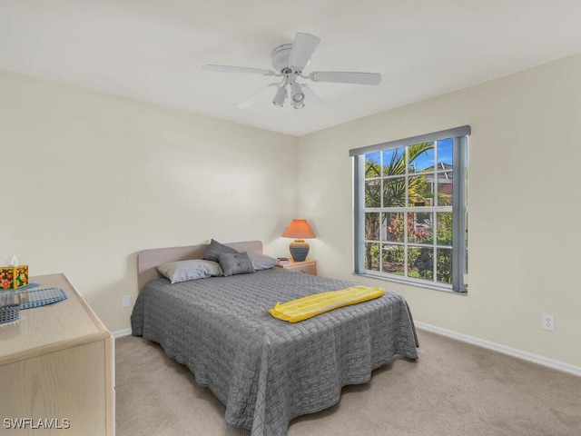 bedroom with baseboards, a ceiling fan, and light colored carpet