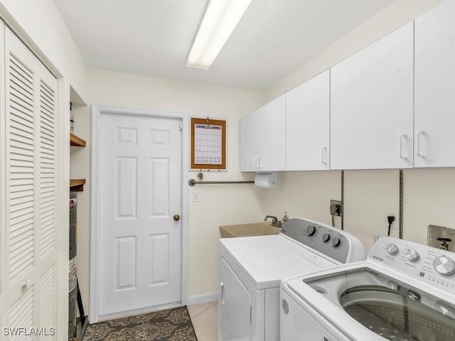 laundry room featuring light tile patterned flooring, independent washer and dryer, a sink, and cabinet space