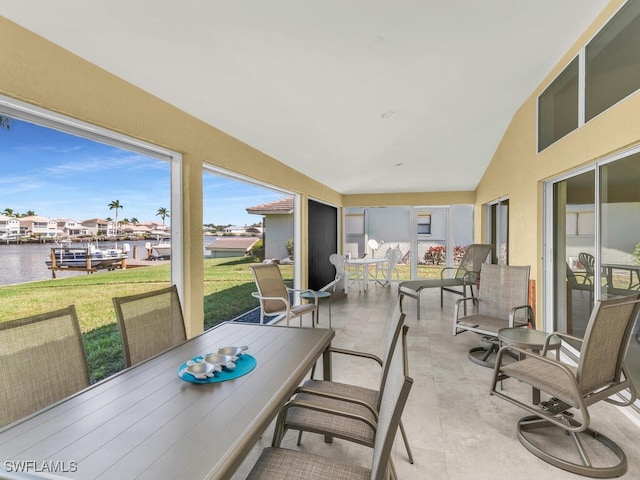 sunroom featuring a water view and vaulted ceiling