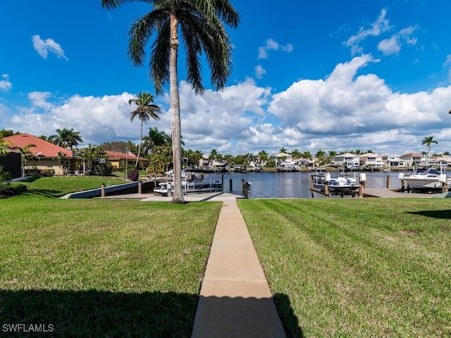 view of dock with a water view and a lawn