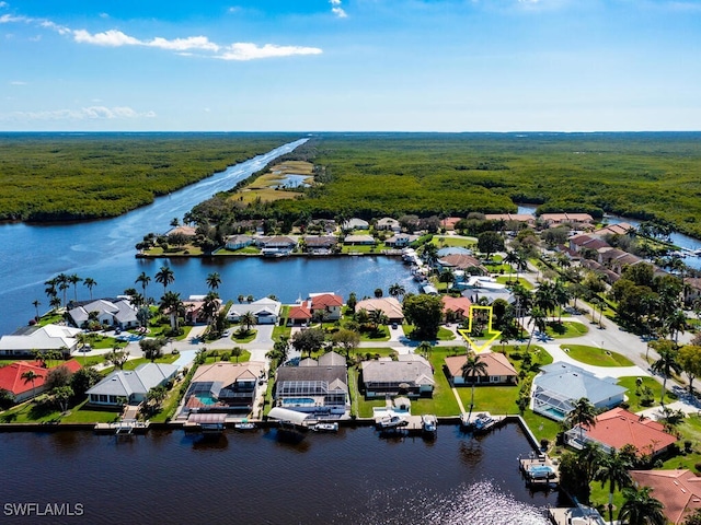 drone / aerial view with a water view, a residential view, and a wooded view