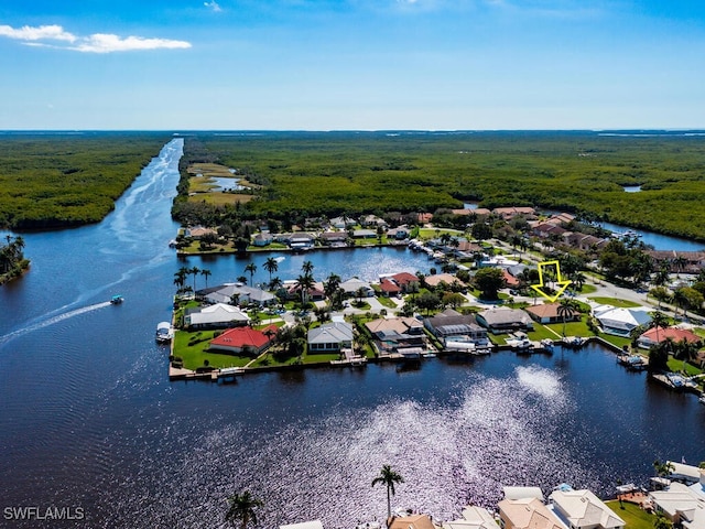 drone / aerial view featuring a residential view, a water view, and a wooded view