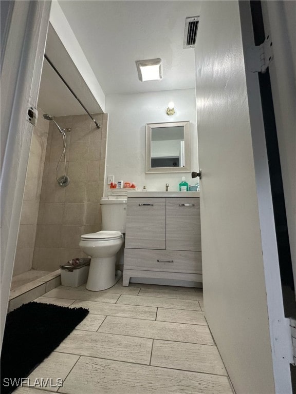 full bath featuring toilet, a stall shower, visible vents, and wood finish floors