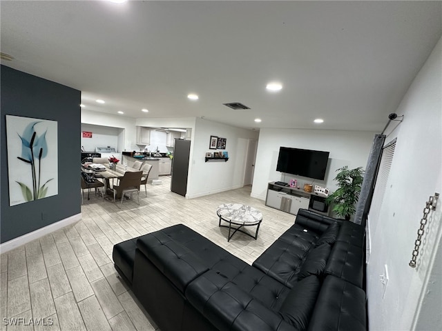 living room with wood tiled floor, visible vents, baseboards, and recessed lighting