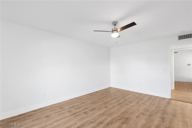 spare room with light wood-style floors, ceiling fan, visible vents, and baseboards