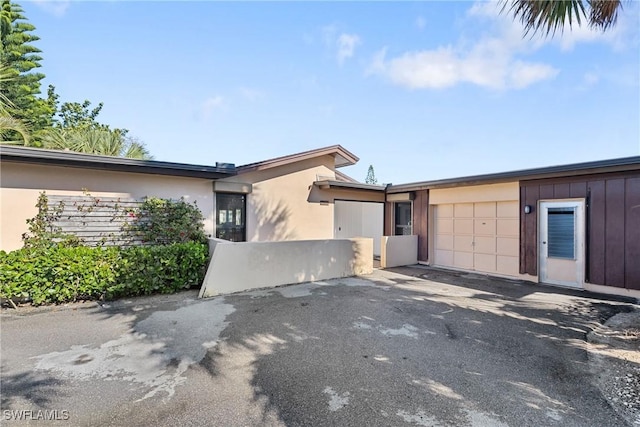 view of front facade featuring driveway, an attached garage, and stucco siding