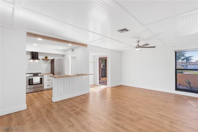 kitchen with visible vents, wall chimney exhaust hood, appliances with stainless steel finishes, open floor plan, and light wood-style floors