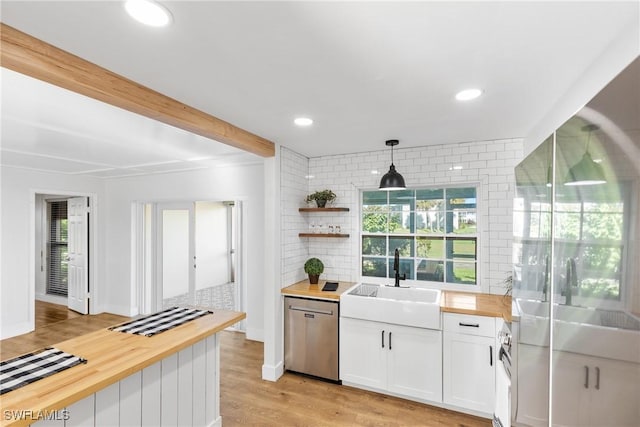 kitchen featuring a wealth of natural light, a sink, wooden counters, and dishwasher