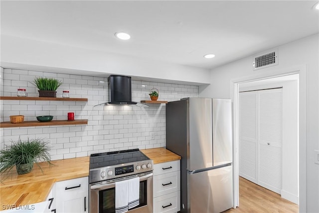 kitchen with wood counters, visible vents, appliances with stainless steel finishes, ventilation hood, and open shelves