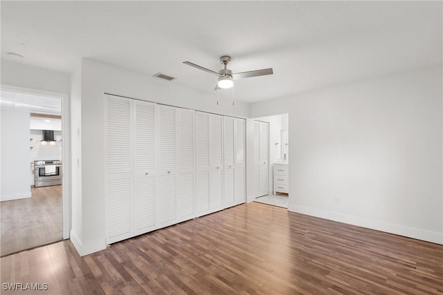 unfurnished bedroom with ceiling fan, wood finished floors, visible vents, and baseboards