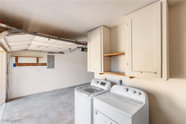 clothes washing area featuring a garage, cabinet space, electric panel, and washer and dryer