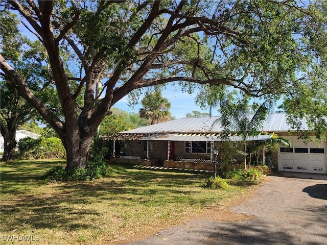 27253 Rio Vista Cir, Bonita Springs, FL 34135 - single story home featuring an attached garage, driveway, a front yard, and metal roof