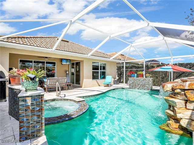 view of swimming pool featuring ceiling fan, a patio, a lanai, and a pool with connected hot tub