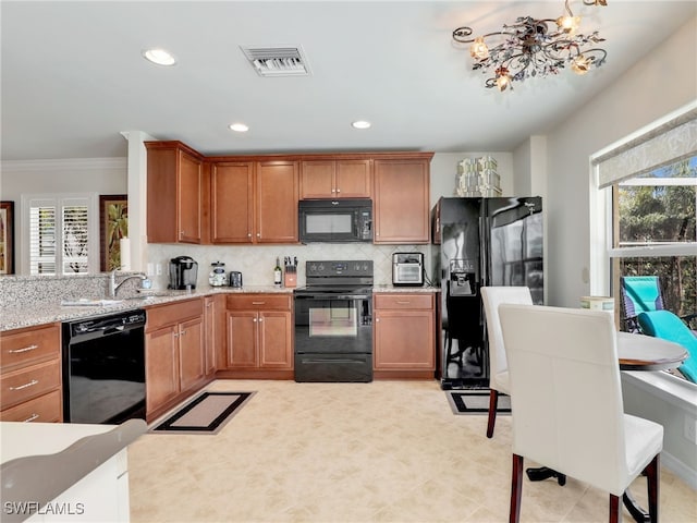 kitchen with black appliances, plenty of natural light, a sink, and visible vents