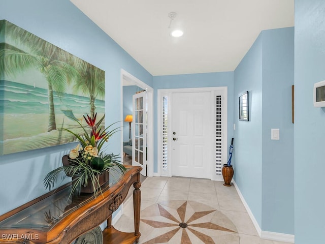 foyer entrance featuring baseboards and light tile patterned floors