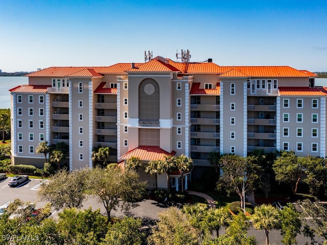 view of property featuring uncovered parking and a water view