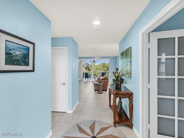 hall with baseboards and light tile patterned floors