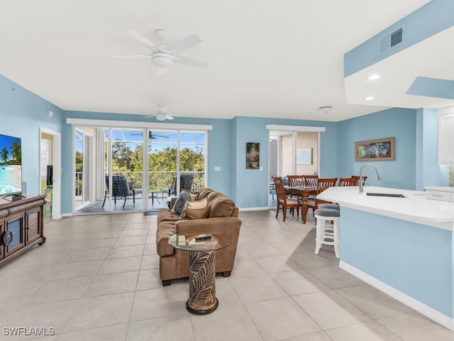 living room featuring light tile patterned floors, recessed lighting, a ceiling fan, visible vents, and baseboards