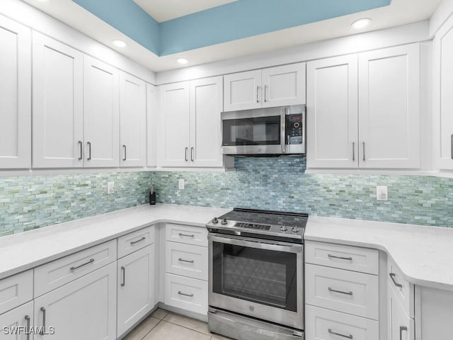 kitchen featuring white cabinets, stainless steel appliances, light countertops, and light tile patterned flooring