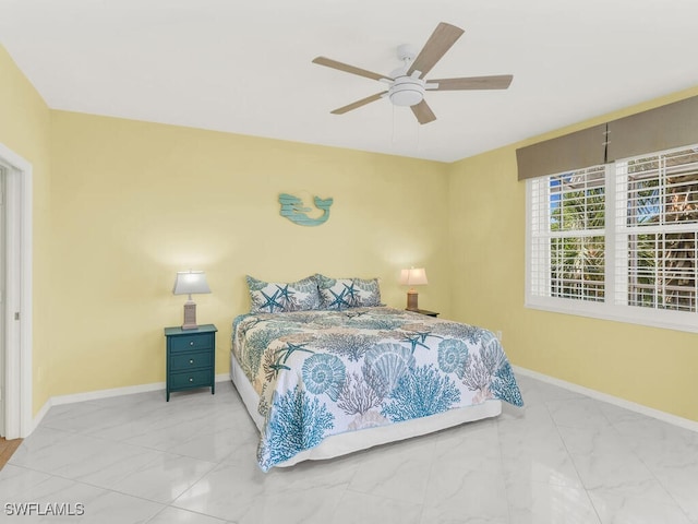 bedroom featuring a ceiling fan, marble finish floor, and baseboards