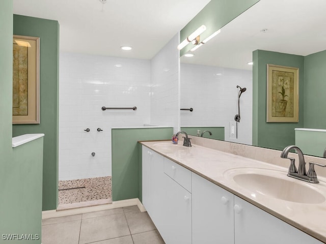 bathroom with tile patterned flooring, double vanity, a sink, and walk in shower