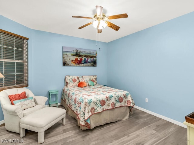 bedroom with wood finished floors, a ceiling fan, and baseboards