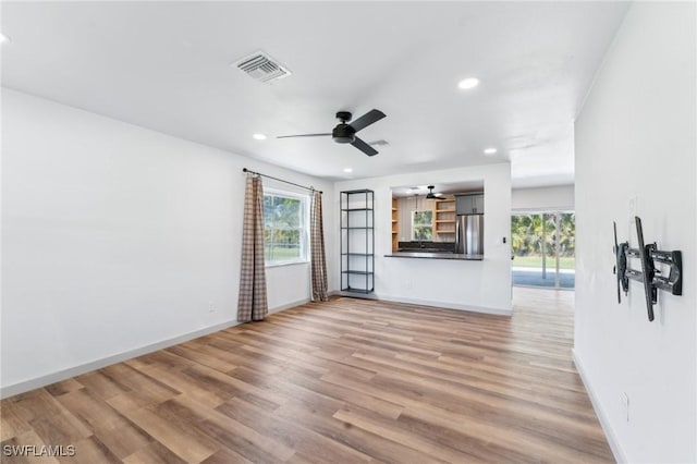 empty room featuring baseboards, visible vents, wood finished floors, and recessed lighting