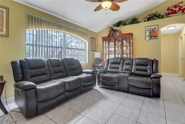 living room featuring light tile patterned floors, vaulted ceiling, arched walkways, and a ceiling fan