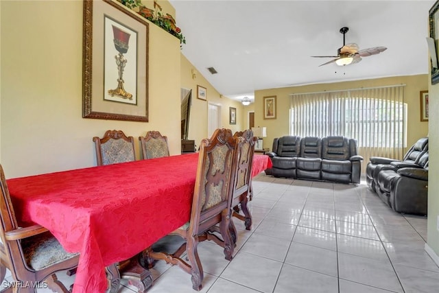 dining area featuring vaulted ceiling, visible vents, light tile patterned flooring, and a ceiling fan