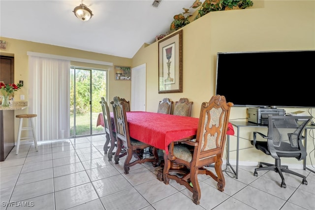 dining room with lofted ceiling, baseboards, and light tile patterned floors