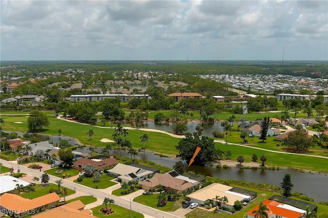 drone / aerial view with a residential view, view of golf course, and a water view