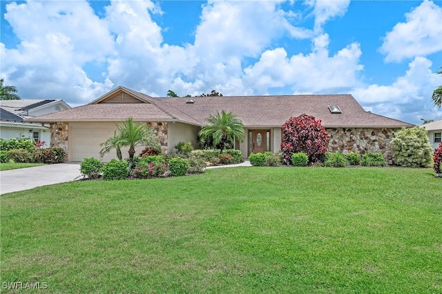 view of front of property with stone siding, a front lawn, an attached garage, and driveway