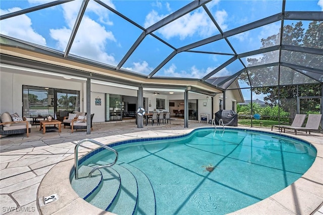 pool featuring a patio, grilling area, glass enclosure, ceiling fan, and an outdoor living space