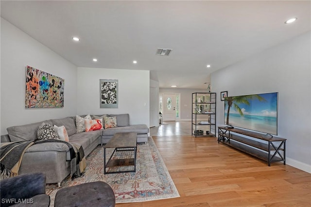 living area with baseboards, light wood finished floors, visible vents, and recessed lighting