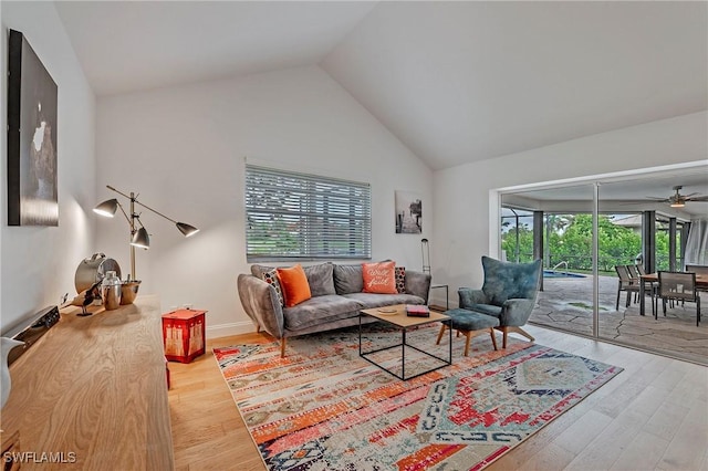 living area featuring high vaulted ceiling, wood finished floors, and a ceiling fan