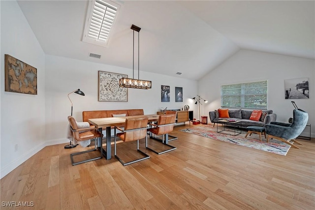 dining space featuring visible vents, an inviting chandelier, light wood-style floors, high vaulted ceiling, and baseboards