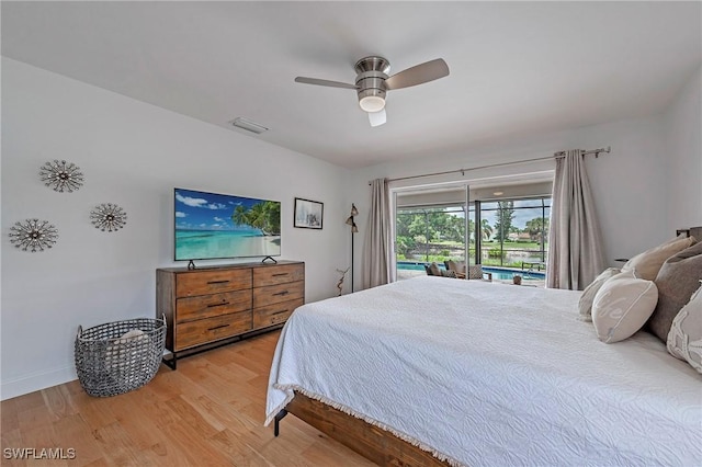 bedroom with baseboards, visible vents, a sunroom, ceiling fan, and wood finished floors