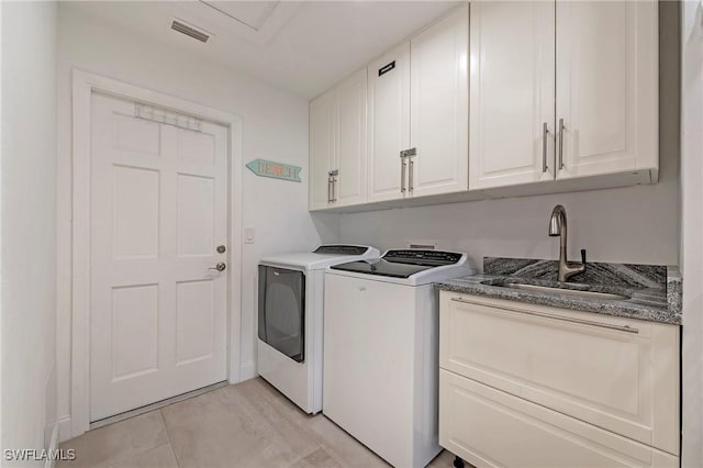 laundry area with cabinet space, independent washer and dryer, visible vents, and a sink