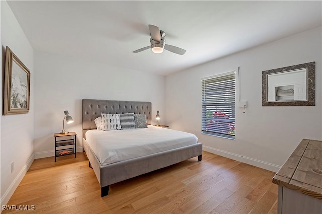 bedroom with light wood-style floors, baseboards, and a ceiling fan