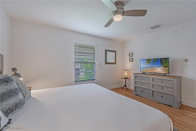 bedroom with baseboards, visible vents, ceiling fan, and light wood finished floors