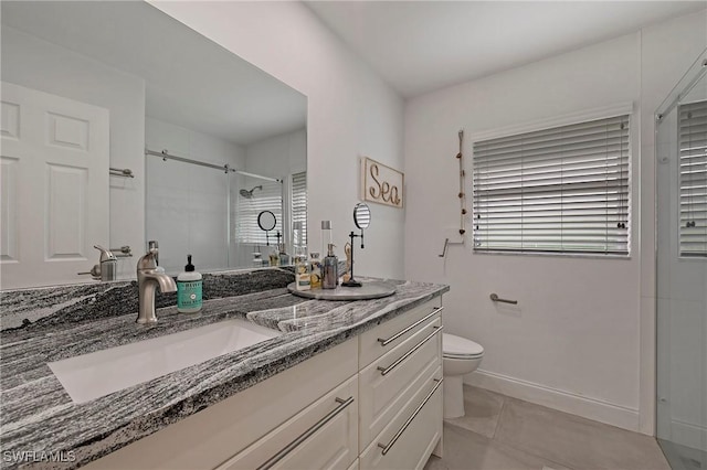 bathroom featuring baseboards, toilet, tile patterned floors, a tile shower, and vanity