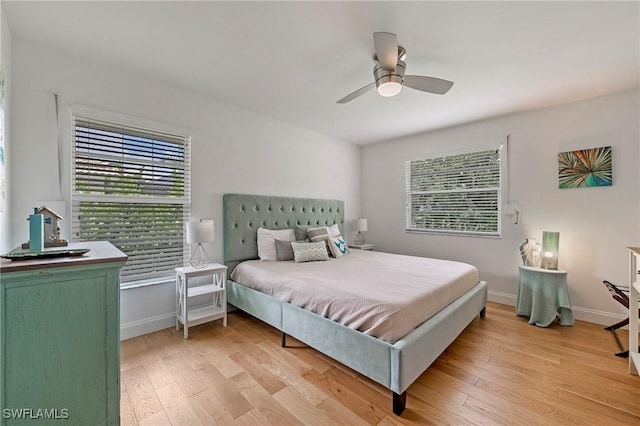 bedroom featuring light wood-style flooring, multiple windows, and baseboards