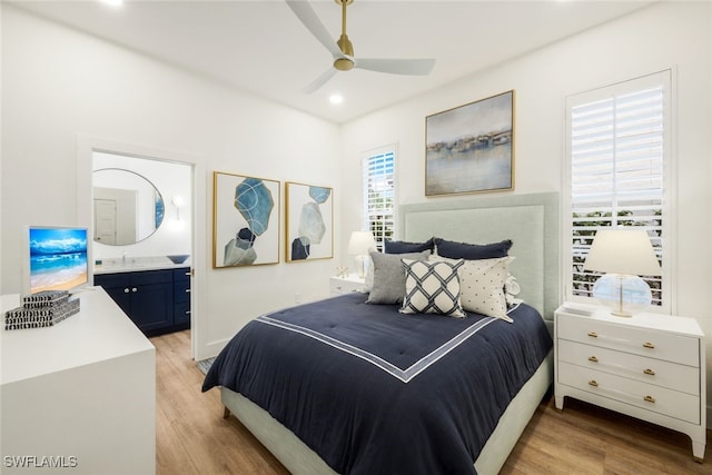 bedroom featuring light wood-type flooring, a sink, ensuite bath, and recessed lighting