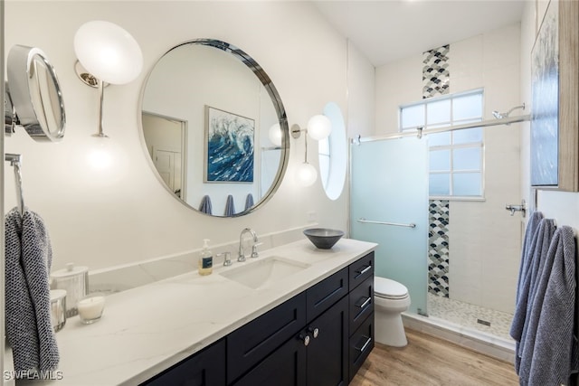 full bath featuring toilet, a stall shower, wood finished floors, and vanity