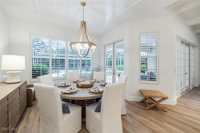 dining space with light wood-style flooring, baseboards, a notable chandelier, and french doors