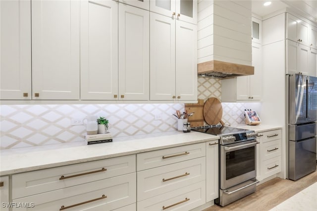 kitchen with white cabinetry, glass insert cabinets, stainless steel appliances, and light stone counters